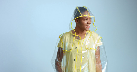 pretty mixed race woman with short hair in transparent raincoat