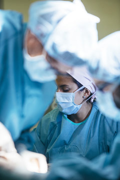 Woman working with doctors in operating room