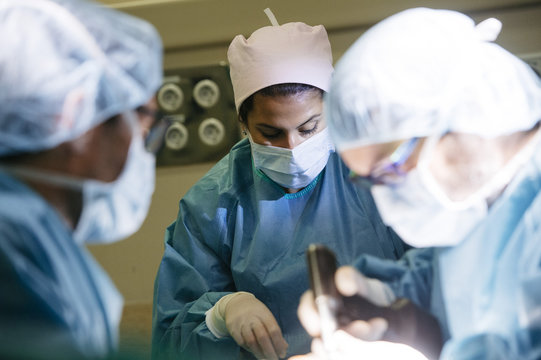 Woman working with doctors in operating room