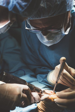 Surgeons conducting operation with tools