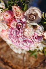 wedding rings with bouquet on a tree stump