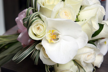 beautiful white and yellow wedding bouquet of roses and orchids on dark background