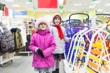 sisters choosing   sled in   children's New Year's store