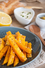 Snack. Pumpkin pieces baked in spices on a plate with cream sauce