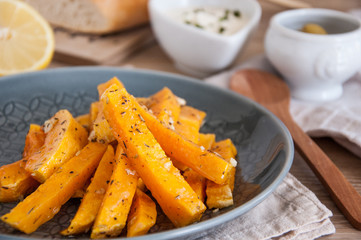 Snack. Pumpkin pieces baked in spices on a plate with cream sauce