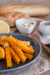 Snack. Pumpkin pieces baked in spices on a plate with cream sauce