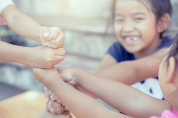 Children playing and holding hands together,stack of children's fist hands