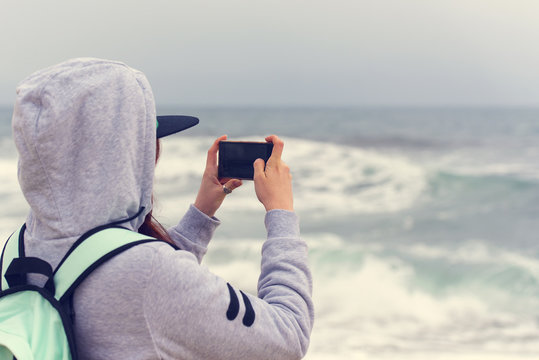 Woman tourist taking pictures of sea with mobile phone, woman using mobile phone at sea