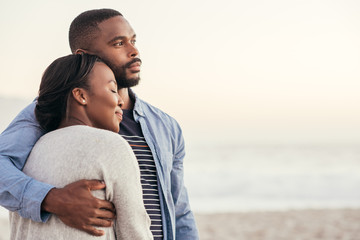 Smiling young African couple enjoying a sunset at the beach - Powered by Adobe