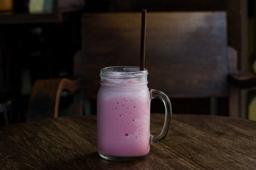 Beverage, pink milk. Cold sweet of pink milk in glass, delicious drink on vintage of wooden table set. Asia local drink.