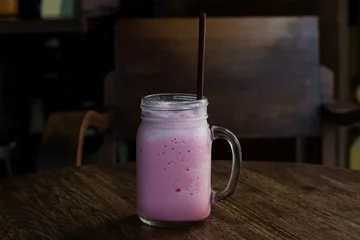 Photo sur Plexiglas Milk-shake Beverage, pink milk. Cold sweet of pink milk in glass, delicious drink on vintage of wooden table set. Asia local drink.