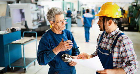 Factory worker discussing data with supervisor in metal factory