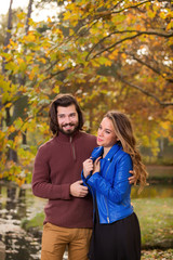 Fototapeta premium Cute couple in park filled with autumn colors.
