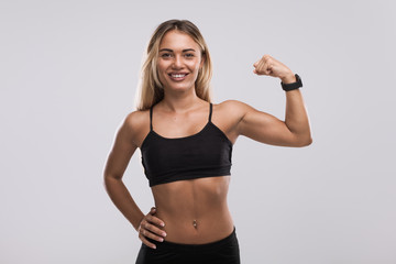 Smiling fit woman showing bicep