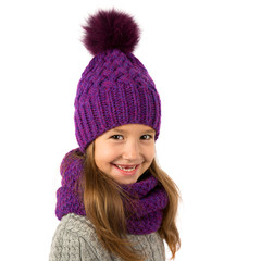 Beautiful little girl in winter warm purple hat and scarf isolated on white. Children winter clothes