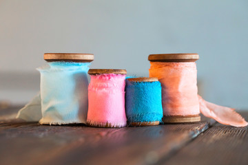 Colored coils of colored cotton ribbons on wooden surface