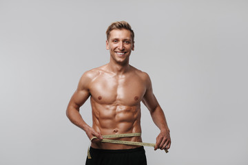 Smiling man measuring waistline