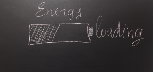 Fototapeta premium drawn a battery on a blackboard with text: Energy - loading