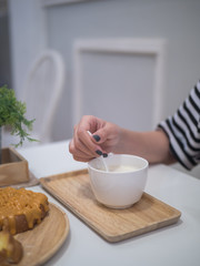Woman hand holding the spoon to stir hot milk