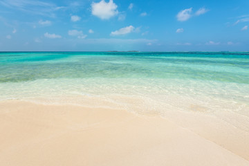 Fototapeta na wymiar Empty tropical beach background. Horizon with resort island, sky and white sand in Maldives.