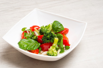 Salad from tomatoes, broccoli, basil, onions with spices