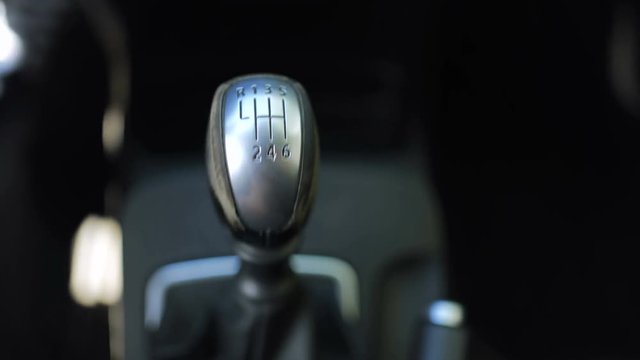 Angry and frustrated man driving a car with the manual transmission gearbox and smashing the gear stick