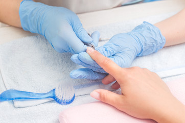 The master prepares the nails for manicure