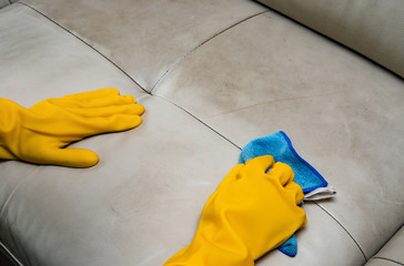 cleaning leather sofa at home with wet towel