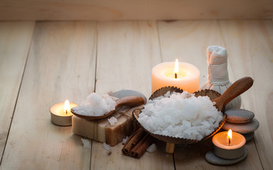 Herbal compress, towel, lotus flower and luffa scrub on wooden table, spa and wellness concept