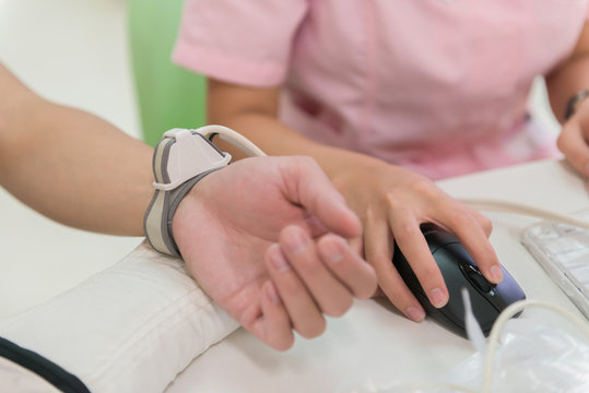 nurse using medical facility checking pulse and blood pressure etc for a man