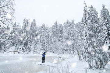 Fototapeta na wymiar Man in snow landscape Finland in forest with trees coverd in snow