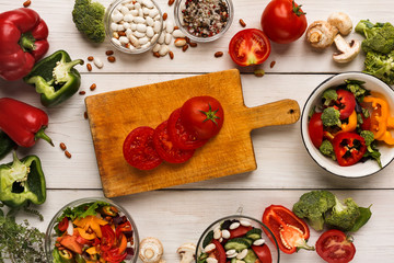 Various salad bowls on white wooden table, top view