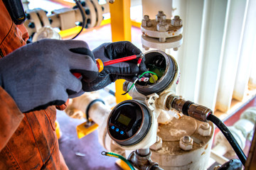 Hand of technician,Instrument technician on the job calibrate or function check level transmitter in oil and gas process. Level transmitter, send signal and reading pressure in the system.
