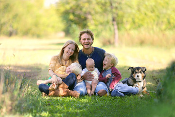 Fototapeta premium Happy Family Laughing Together with Dog Outside