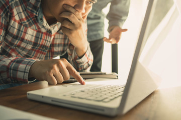 Businessman's hand pointing at laptop at meeting.