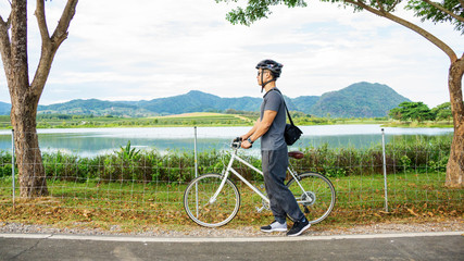 Men riding a bicycle near a lake at Singha park Chiang Rai, Thailand.