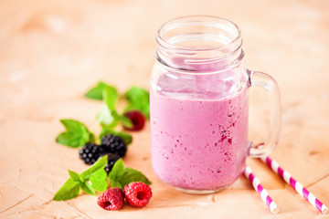 Delicious blackberry raspberry smoothie with mint and fresh berries in glasses. Selective focus.
