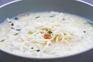 Cooking instant noodles, put egg and vegetables with hot soup in bowl.junk food or fast food concept.