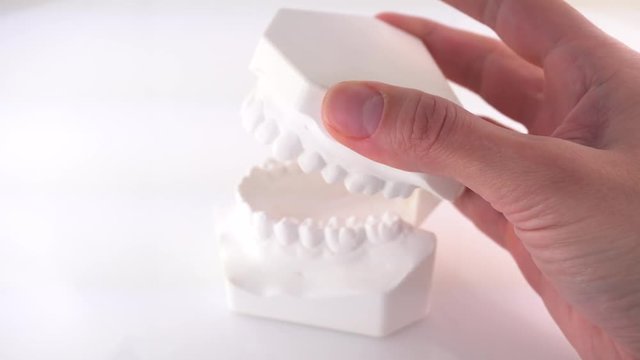 False teeth biting into a woman's hand