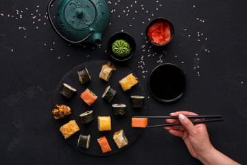Set of sushi maki and rolls on black background