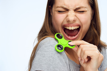 girl holds a green spinner and screams