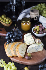 snacks of blue cheese, olives, bread and grapes