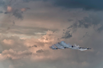 Five airplanes formation on a sunset sky at an air show