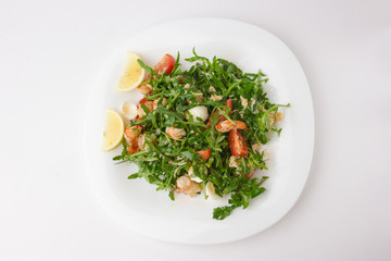 Salad with arugula and shrimp. Fresh dish with arugula, cherry tomatoes, shrimp on a plate.