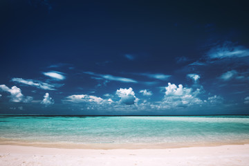 Sandy beach, clear see-through sea and blue sky. Maldives