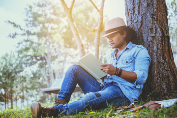 Asian man relax in the holiday. Study read a book. Read a book In the garden on the Moutain. In Thailand