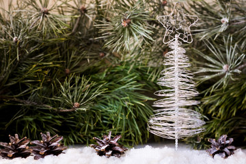 Christmas tree made of wire on a background of fir branches
