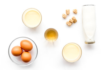 Ingredients for eggnog. Eggs, milk, cinnamon, whiskey on white background top view