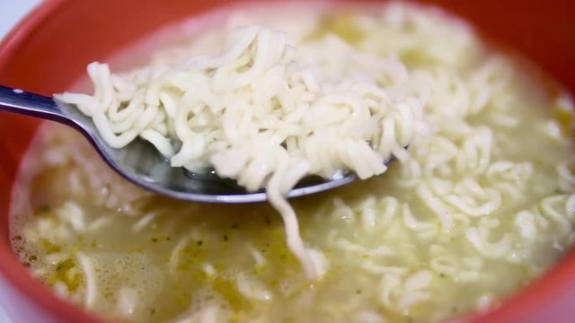 Man stirs instant noodles with a spoon