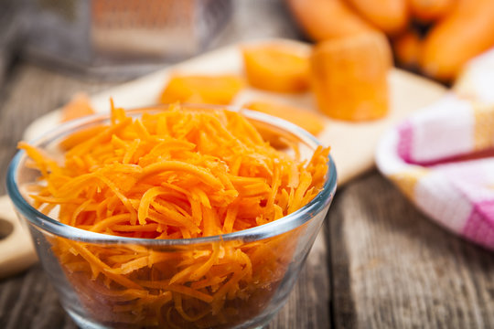 Grate  carrots in a bowl